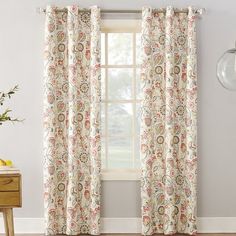 the curtains in this room are decorated with flowers and paisley designs, while the window is closed