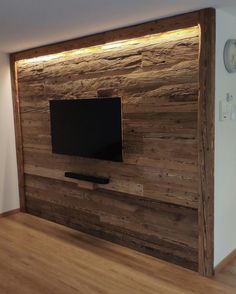 a flat screen tv mounted to the side of a wooden wall