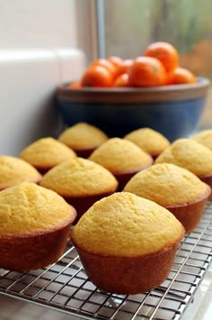 muffins on a cooling rack with oranges in the background