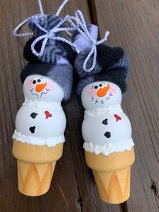 two ice cream cones with snowmen on them