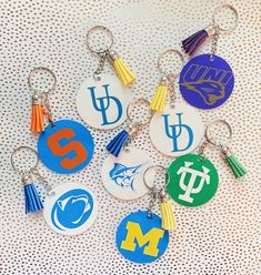 six different university key chains with the letters m and w on them, all in various colors