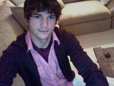 a young man sitting on the floor in front of a couch