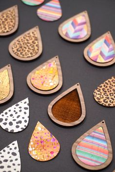 wooden tears with different patterns and colors are displayed on a black surface, surrounded by polka dots