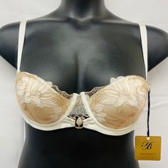 -Cut Down Push Up Cup -Lilium Embroidery Of Swiss-Design -Thermo-Cut Flowers On Crystal Tulle -Removeable Shoulder Straps -Gold-Plated Hardware & Pearl Barbell Ring -Hook & Eye Fastening -Comes With Honey Birdette Hanger Delicate Fitted Wedding Bra, Delicate Wedding Bra, Feminine Cream Lace Bra, Wedding Lace Bra In Beige, Cream Bra With Delicate Lace, Elegant White Bra With Lined Body, Beige Underwire Bra For Wedding, Cream Lace Underwire Bra, Elegant Full Cup Cream Bra