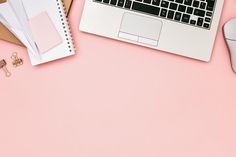 an open laptop computer sitting on top of a pink desk