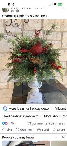 a vase filled with red berries and greenery on top of a table