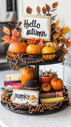 three tiered tray filled with pumpkins and books