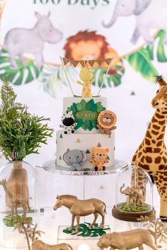 there is a cake with animals on it and other decorations in front of the cake