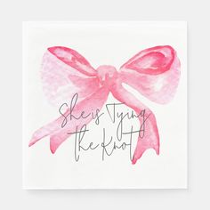 a pink bow with the words she's tying the knot on it in cursive writing