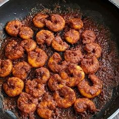 fried food being cooked in a skillet on the stove top with sauce and seasoning