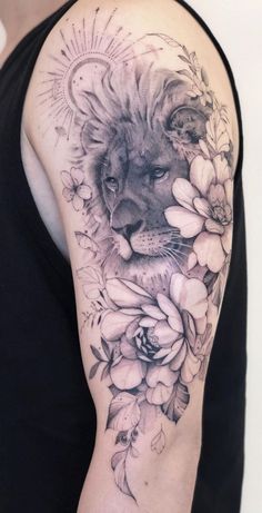 a woman's arm with a lion and flowers tattoo on the left side of her body