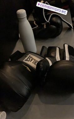 boxing gloves and water bottle sitting on a table