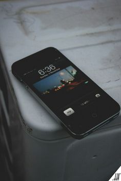 an iphone sitting on top of a white box