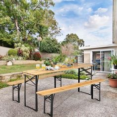 an outdoor picnic table with two benches in front of it and a potted plant next to it