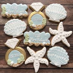 decorated cookies with shells and seashells are arranged on a wooden surface, including the words future you're married