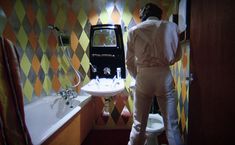 a woman standing in front of a bathroom sink next to a bathtub and toilet