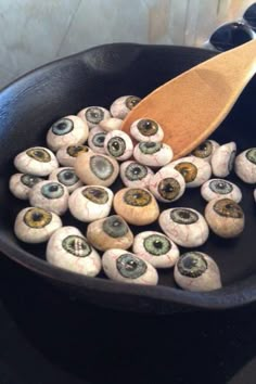 mushrooms are being cooked in a skillet with a wooden spoon on the stove top