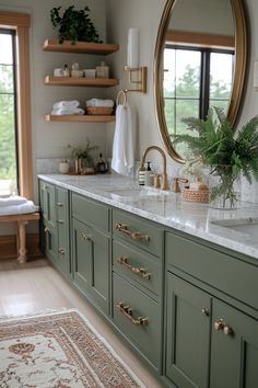 a bathroom with green cabinets and marble counter tops in front of a large round mirror