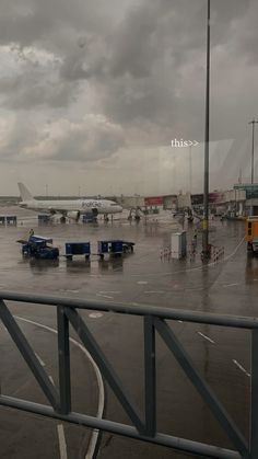 an airport tarmac with several planes parked on the tarmac and cloudy skies in the background