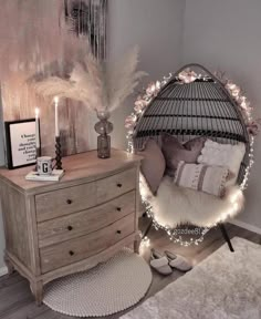 a bedroom with a bed, dresser and hanging birdcage decorated with fairy lights