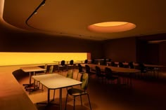 an empty classroom with tables and chairs in the center, lit up at night time