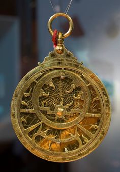 an antique gold clock hanging from a chain