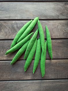 green beans are laid out on a wooden surface