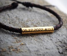 a close up of a bracelet on the ground with a name tag attached to it