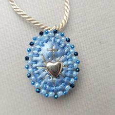 a blue beaded pendant with a heart on it