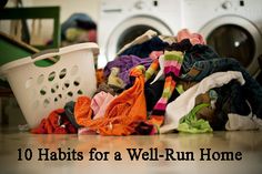 a pile of clothes sitting on top of a floor next to a laundry basket and dryer