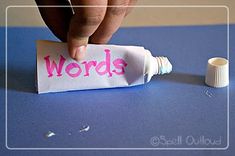 a hand is writing words on a piece of paper next to a tube of toothpaste