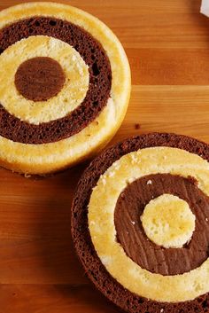 two brown and white cakes sitting on top of a wooden table