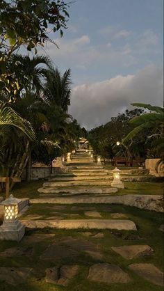 a long stone path lined with trees and lights