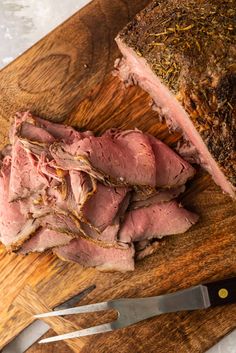 the meat is sliced and ready to be served on the cutting board with knifes