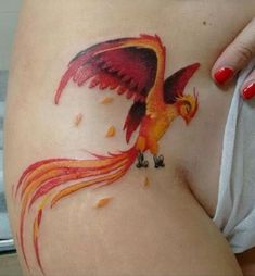 a woman's stomach with a bird tattoo on it