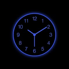 a clock that is glowing in the dark with blue numbers on it's face