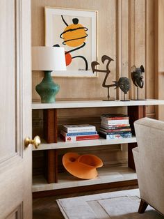 a living room with a chair, lamp and bookshelf