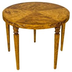 a round wooden table with carved legs