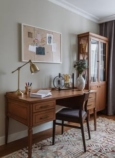 a desk with a chair, lamp and pictures on the wall