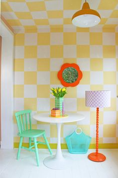 two chairs and a table in a room with checkered wall paper on the walls