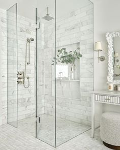 a white bathroom with a walk in shower next to a sink and mirror on the wall