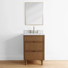 a bathroom vanity with two drawers and a mirror on the wall above it, in front of a white wall