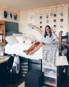 a woman sitting on top of a bed in a room with lots of pictures and lights