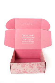 an open pink box with flowers on it and the words i'm city written in white