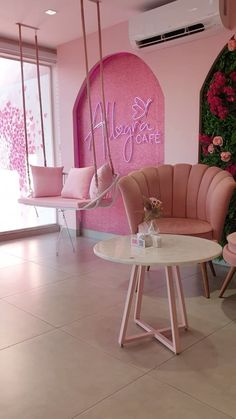 a pink room with two chairs and a table