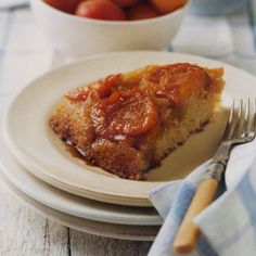 a piece of cake sitting on top of a white plate next to a bowl of fruit