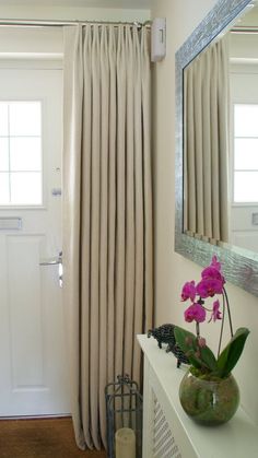 a vase with flowers sitting on top of a white shelf in front of a door