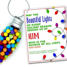 a christmas ornament with candy in it next to a card that says, may the beautiful lights of every holiday season remind us off him who is the source of all