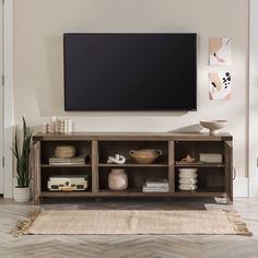 a flat screen tv mounted to the side of a wooden entertainment center in a living room