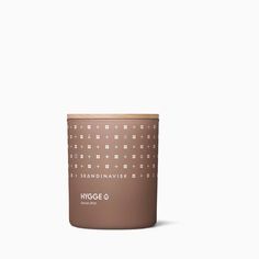 a candle that is sitting on top of a white surface with the words hygge 6 in front of it